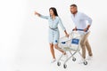 Happy couple running with a shopping cart Royalty Free Stock Photo