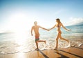 Happy couple running on a tropical beach Royalty Free Stock Photo