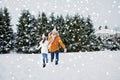 Happy couple running in winter snow Royalty Free Stock Photo