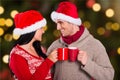 Happy couple in santa hat toasting coffee mugs Royalty Free Stock Photo