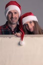 Couple in Santa hats with banner Royalty Free Stock Photo