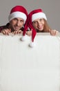 Couple in Santa hats with banner Royalty Free Stock Photo