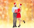 Happy couple in santa hats with red sale sign Royalty Free Stock Photo