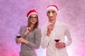 Happy couple in santa hats with wine in glasses holding mask near face and celebrating Valentine`s Day Royalty Free Stock Photo