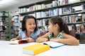 Happy couple school girl reading book in library Royalty Free Stock Photo