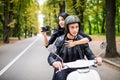 Happy tourist young couple on scooter. Woman making photo on camera while riding outdoors Royalty Free Stock Photo