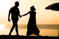 A Happy couple by the sea at sunset on travel silhouette in nature Royalty Free Stock Photo