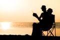 A Happy couple by the sea at sunset on travel silhouette in nature Royalty Free Stock Photo