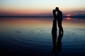 A happy couple at sea with water reflection silhouette background