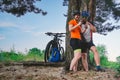 Happy couple searching on map in smartphone destination. man and woman in helmets traveling mountain biking over rough terrain.