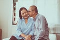 Happy couple senior asian kiss to cheek together on bed at home Royalty Free Stock Photo