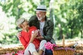 Couple senior man surprise giving gift box to his wife while relaxing in the park Royalty Free Stock Photo