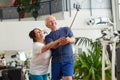 Happy couple of seniors using monopod at gym. Royalty Free Stock Photo