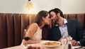 Happy couple, sharing food and kiss for dinner date, embrace or relationship romance at night in restaurant. Man and Royalty Free Stock Photo