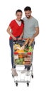 Happy couple with shopping cart full of groceries on white background Royalty Free Stock Photo