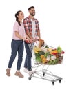 Happy couple with shopping cart full of groceries on white background Royalty Free Stock Photo