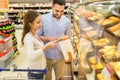 Happy couple with shopping cart at grocery store Royalty Free Stock Photo