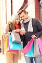 Happy couple shopping in the city with smartphone Royalty Free Stock Photo