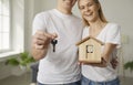 Happy young couple who have bought new house holding toy and keys to their new home Royalty Free Stock Photo