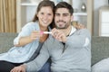 happy couple showing pregnancy test