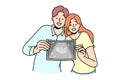 Happy couple showing ultrasound picture of baby