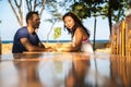 Happy couple sitting at bar table ouside in Thailand .