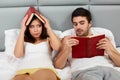 Happy Couple Sitting in Bed Reading Books at Home in Bedroom Royalty Free Stock Photo