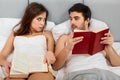 Happy Couple Sitting in Bed Reading Books at Home in Bedroom Royalty Free Stock Photo