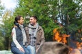 Happy couple sitting on bench near camp fire Royalty Free Stock Photo