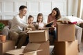 Happy couple unboxing family belongings with daughters.