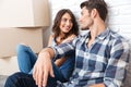 Happy couple sitting on floor around boxes after buying house Royalty Free Stock Photo