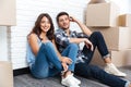 Happy couple sitting on floor around boxes after buying house Royalty Free Stock Photo