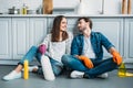 happy couple sitting on floor and looking at each other after cleaning Royalty Free Stock Photo