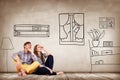 Happy couple sitting on the floor among painted furniture on the wall. Royalty Free Stock Photo