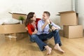 Happy couple sitting on floor unpacking together celebrating with champagne toast moving in new house Royalty Free Stock Photo