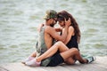 Happy couple sitting and hugging on pier Royalty Free Stock Photo