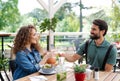 Happy couple sitting outdoors on terrace restaurant, clinking glasses. Royalty Free Stock Photo