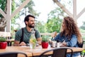 Happy couple sitting outdoors on terrace restaurant, talking. Royalty Free Stock Photo