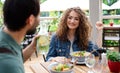 Happy couple sitting outdoors on terrace restaurant, talking. Royalty Free Stock Photo