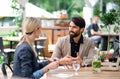 Happy couple sitting outdoors on terrace restaurant, talking.