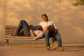 Happy couple sitting on park bench outside Royalty Free Stock Photo