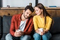 Happy couple sitting on sofa and holding cups Royalty Free Stock Photo