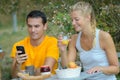 Happy couple sitting in street cafe man using phone Royalty Free Stock Photo