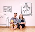 Happy couple sitting in their new flat among painted furniture on the wall. Royalty Free Stock Photo