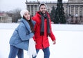 Happy couple skating along ice rink outdoors. Space for text Royalty Free Stock Photo