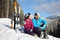 Happy couple with ski equipment sitting on snow. Winter vacation Royalty Free Stock Photo