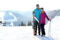 Happy couple with ski equipment spending winter vacation in mountains. Royalty Free Stock Photo