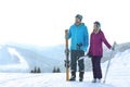 Happy couple with ski equipment spending winter vacation in mountains. Royalty Free Stock Photo