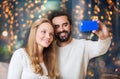 Happy couple with smartphone taking selfie
