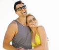 Happy, couple and smile on vacation by beach with sunglasses, hug and holiday for memories or honeymoon. Woman, man and Royalty Free Stock Photo